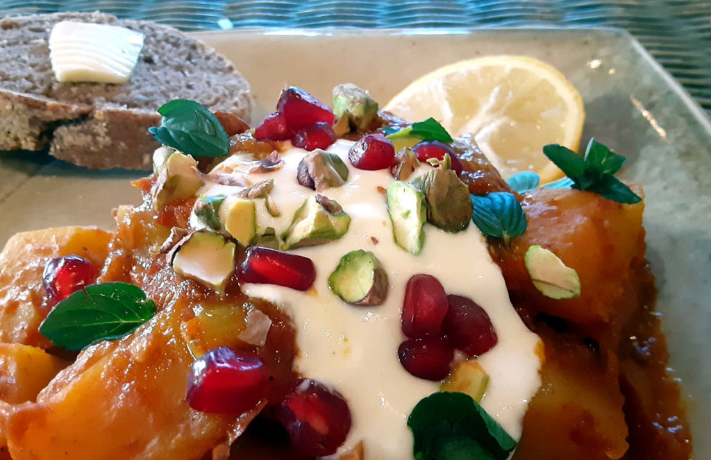 Spiced squash stew topped with garlic yourt, pomegranate, pistachio, and mint.